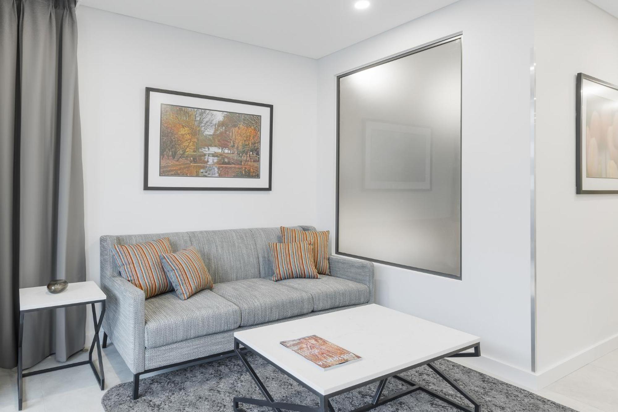 Meriton Suites Canberra Exterior foto A living room with a sofa